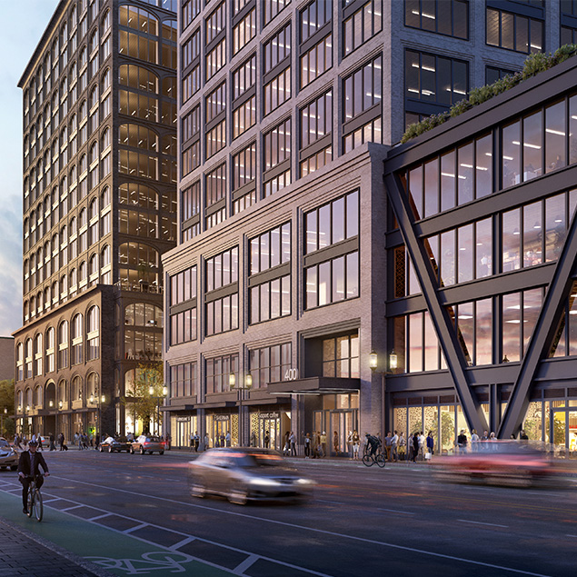 Modern city street with tall office buildings, large windows, people walking on sidewalks, several cars driving by, and a cyclist in the bike lane during twilight. Lights shine from building interiors and street lamps.