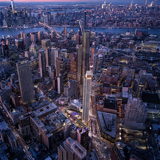 Aerial view of a cityscape at dusk showing tall skyscrapers, illuminated buildings, and a river in the background with bridges connecting different parts of the city.