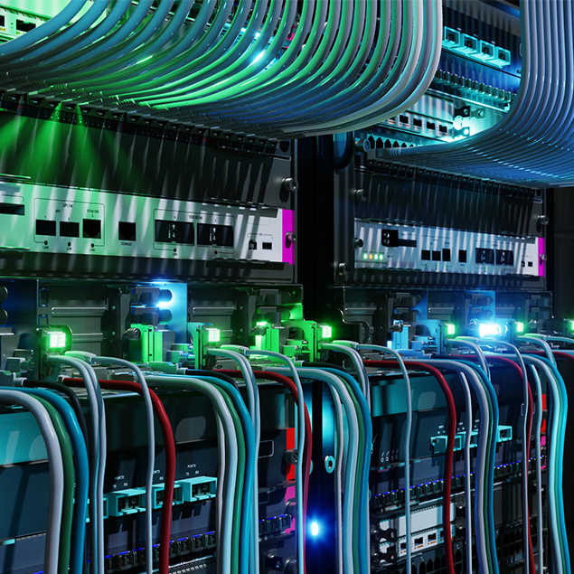 Close-up of network server racks with multiple colorful cables and blinking LED lights, showing a busy, high-tech data center environment.