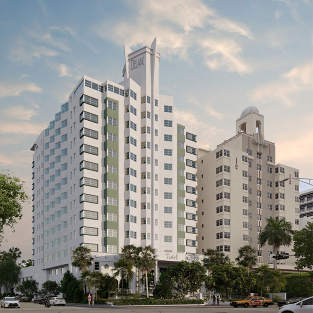 Two tall, white Art Deco-style hotels with vertical green accents and many windows stand side by side under a partly cloudy sky. Palm trees and cars are visible along the street in front of the buildings.