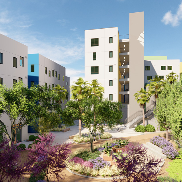 Modern apartment buildings surround a landscaped courtyard with palm trees, flowering plants, and shrubs under a clear blue sky. A staircase is visible on one building, and sunlight brightens the scene.