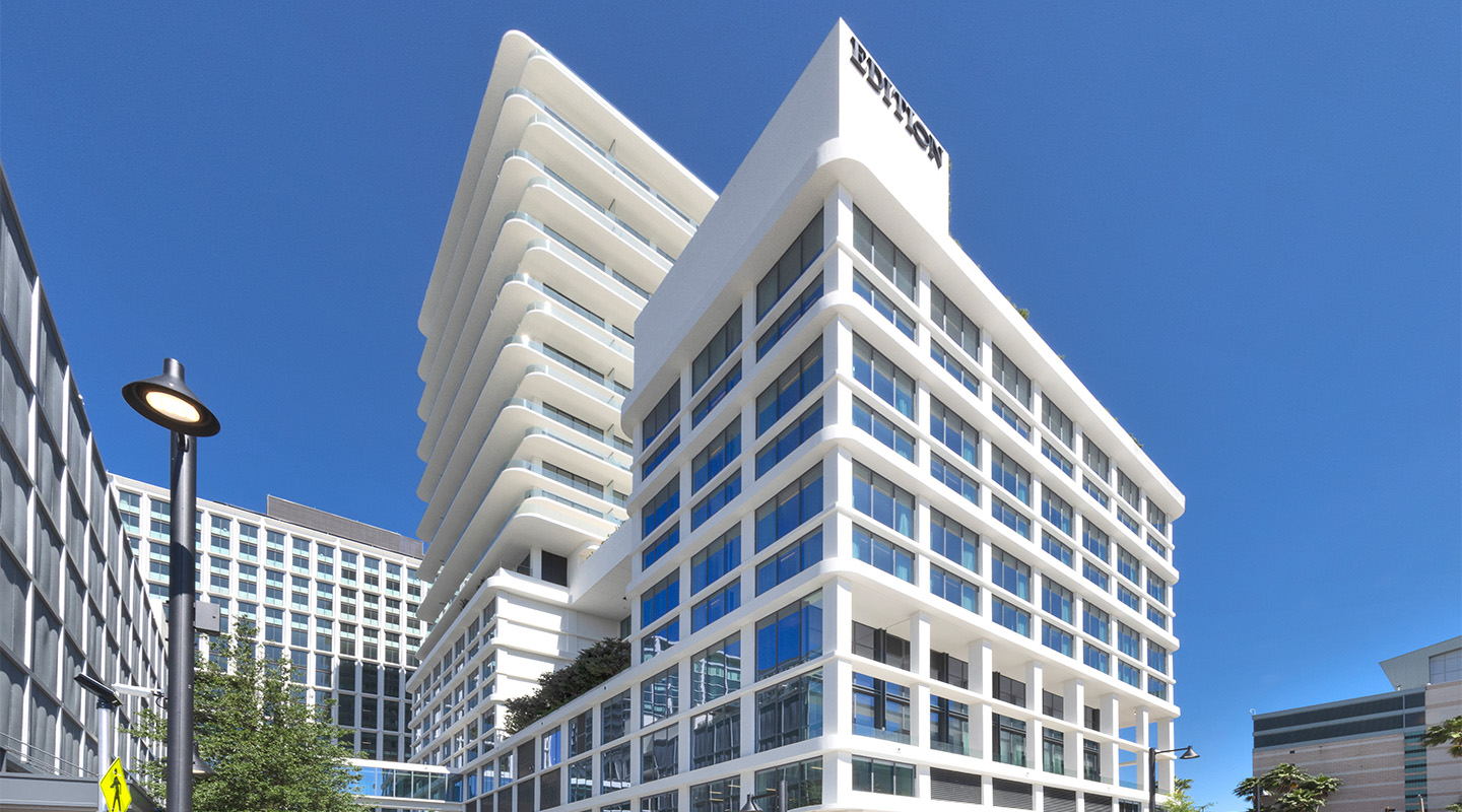 Modern white office building with multiple stories, large glass windows, and protruding horizontal balconies, set against a clear blue sky; the building features the LinkedIn logo at the top corner.