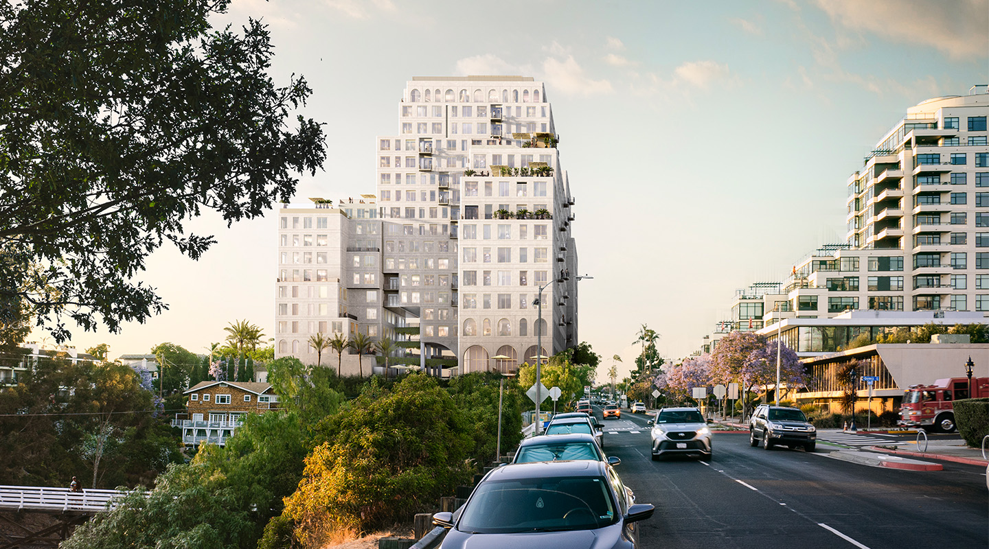 A modern, multi-story white building with arched windows rises behind trees along a busy street lined with parked cars under a partly cloudy sky. Other contemporary buildings and leafy greenery are visible nearby.