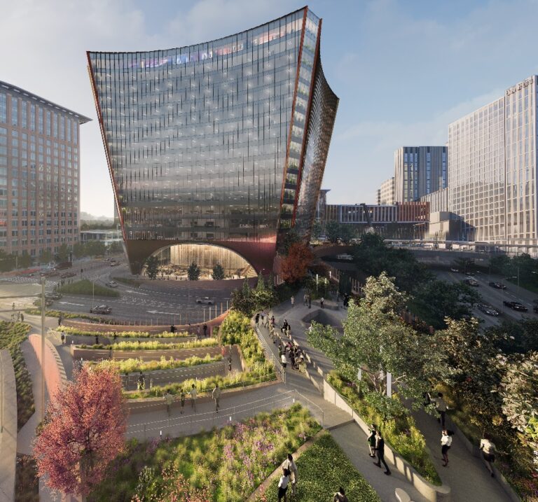 A modern, glass office building with a dramatic inward curve at its base towers over a busy city intersection, surrounded by landscaped paths, green spaces, and groups of people walking.