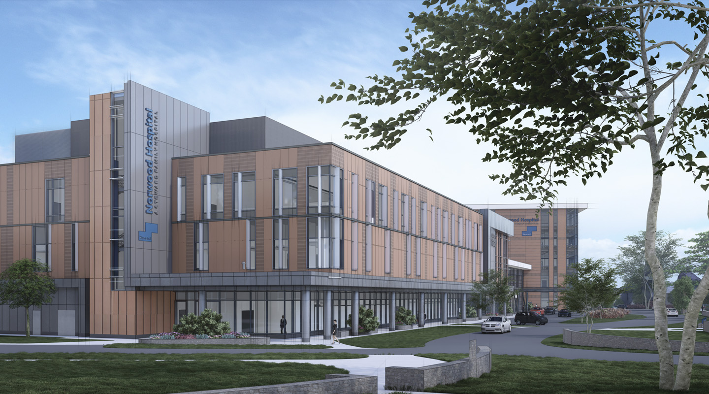 A modern hospital building with large windows and multiple stories, featuring a sign reading Northwest Specialty Hospital. Trees and green lawns surround the facility, and a few cars are parked near the entrance.