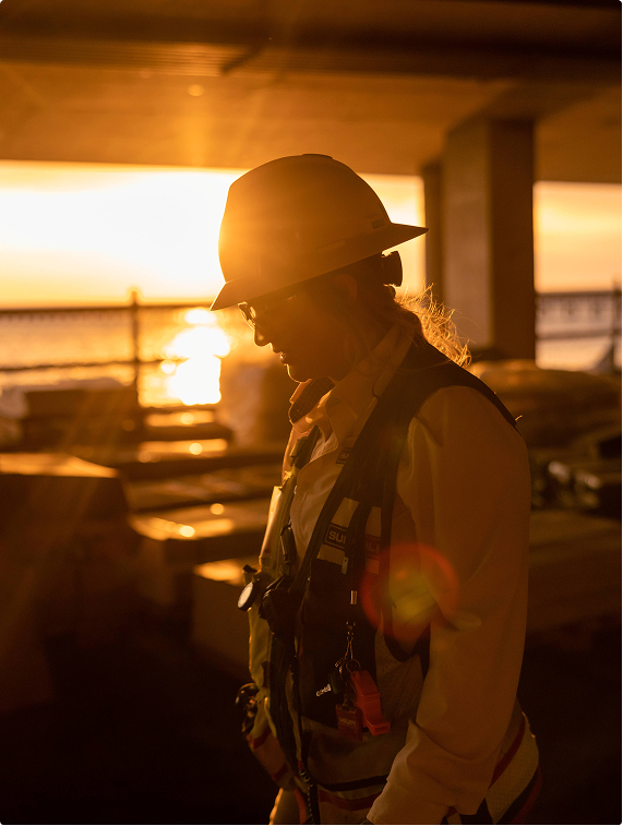 silhouetted suffolk worker with hard hat on taken during sunset on a construction site