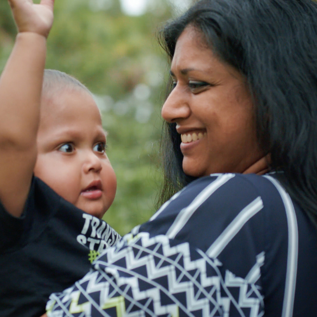 close up of woman of color smiling at a child